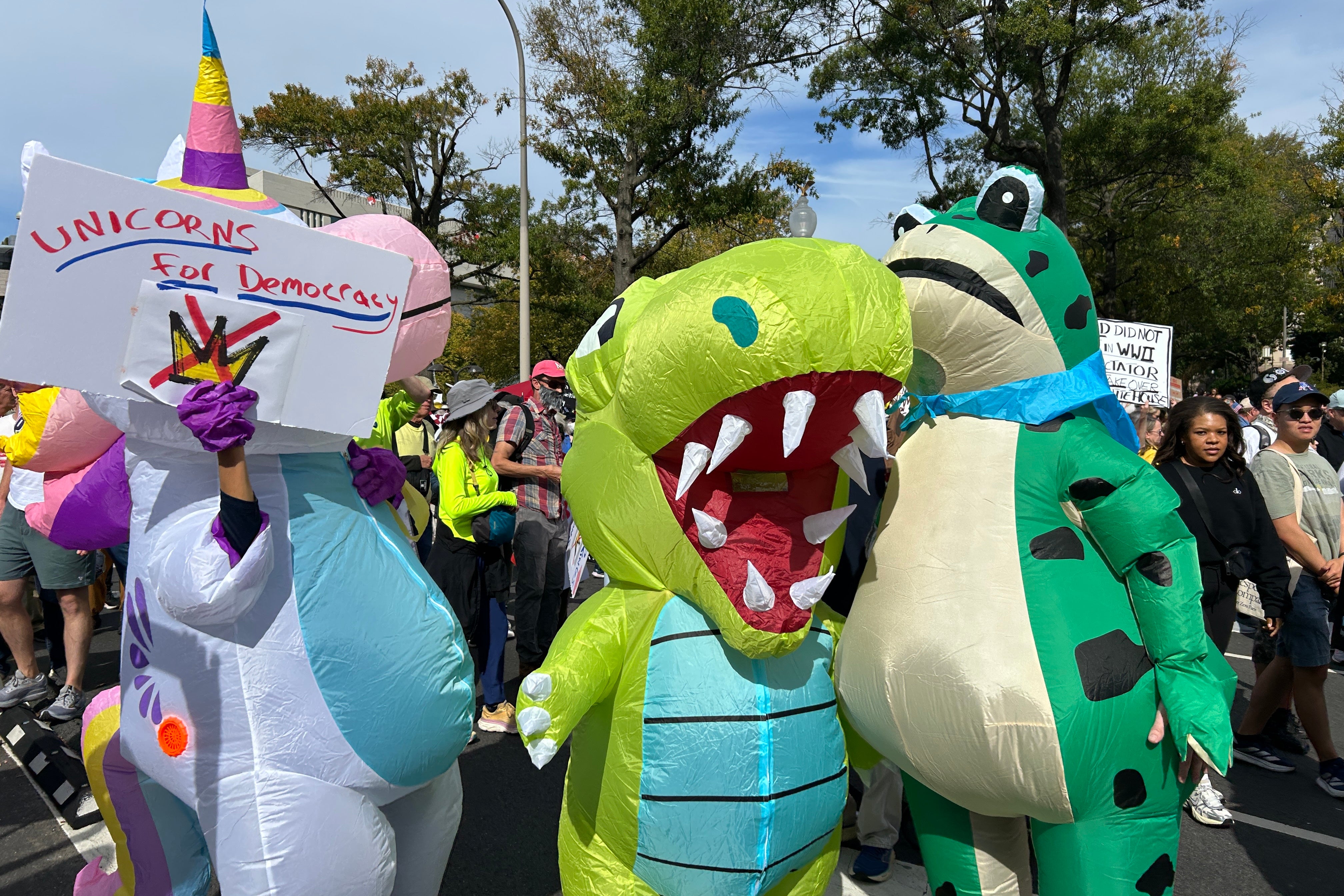 An inflatable unicorn, dinosaur, and frog stand at an anti-Trump protest in D.C.