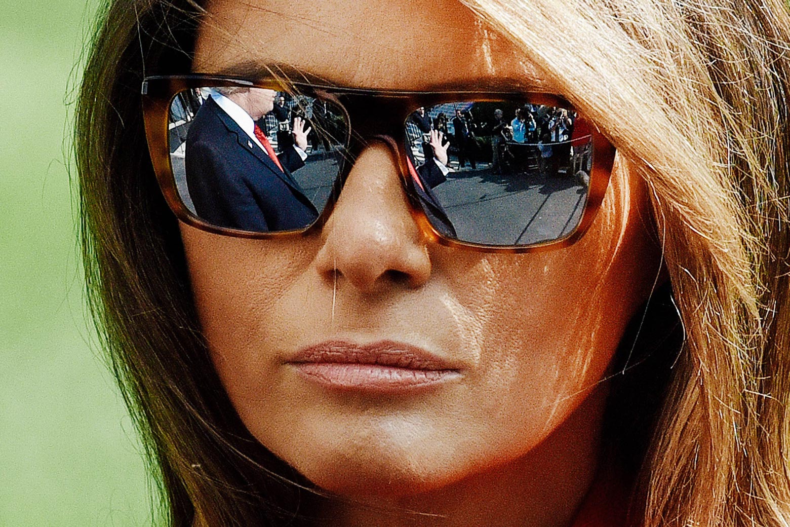 A close-up of Melania Trump's face wearing sunglasses.