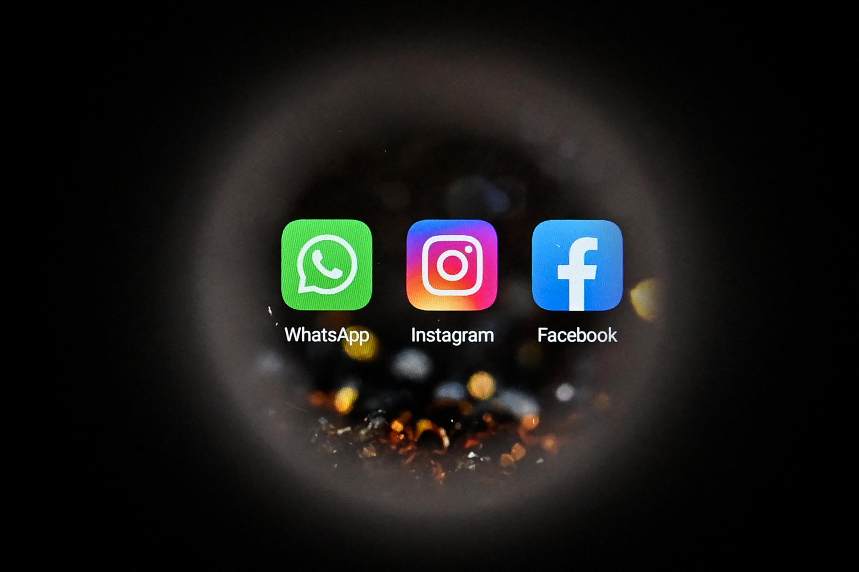 Facebook's logo, WhatsApp's logo, and Instagram's logo on a smartphone screen. 