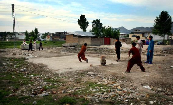 A group of boys plays cricket near the site of the demolished compound of Osama bin Laden