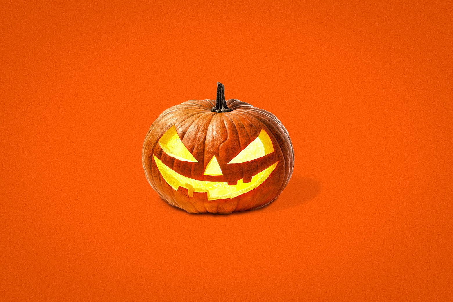 A menacing-looking jack-o-lantern against an orange background.