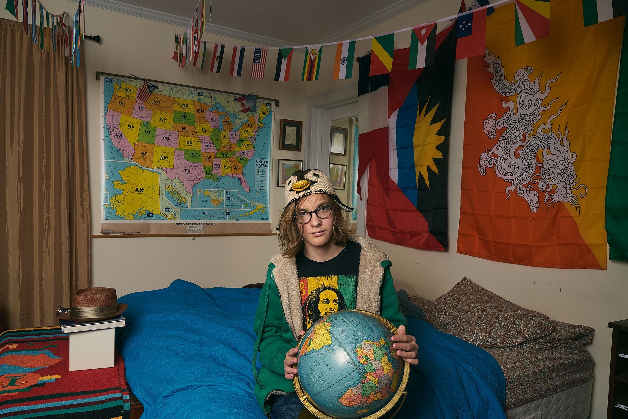 Satchel, holding a globe in his bedroom, 10th grade.