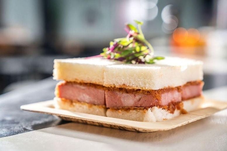Fried mortadella sandwich on crustless white bread on a plate, at Katana Kitten in NYC