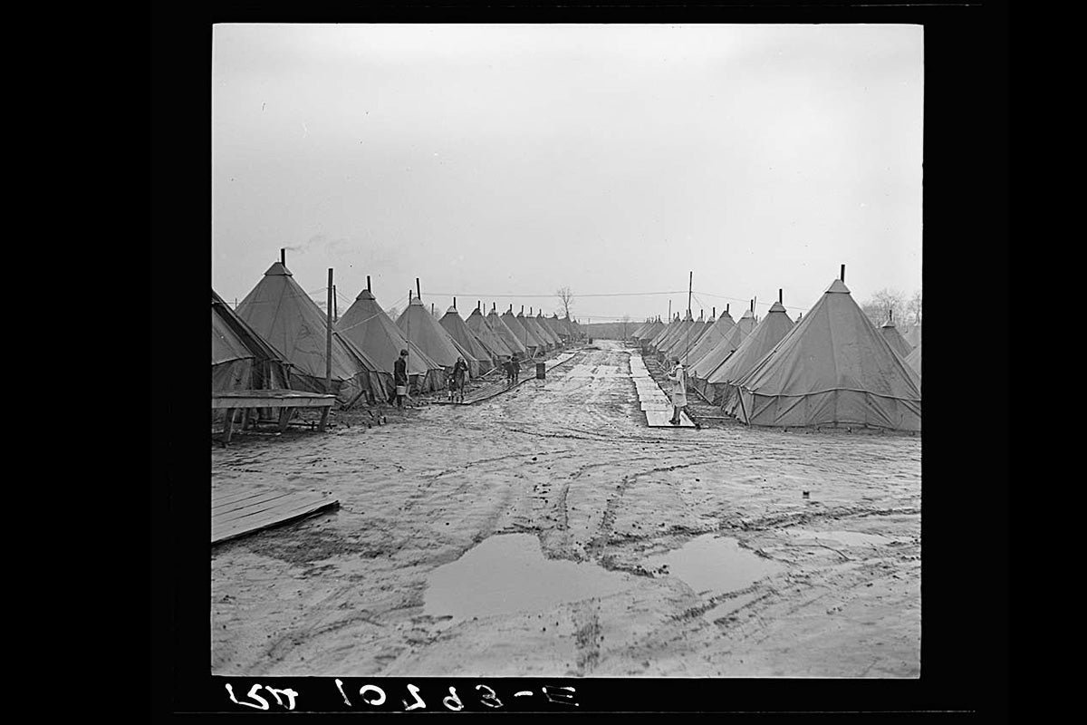 Tents line a muddy alley.