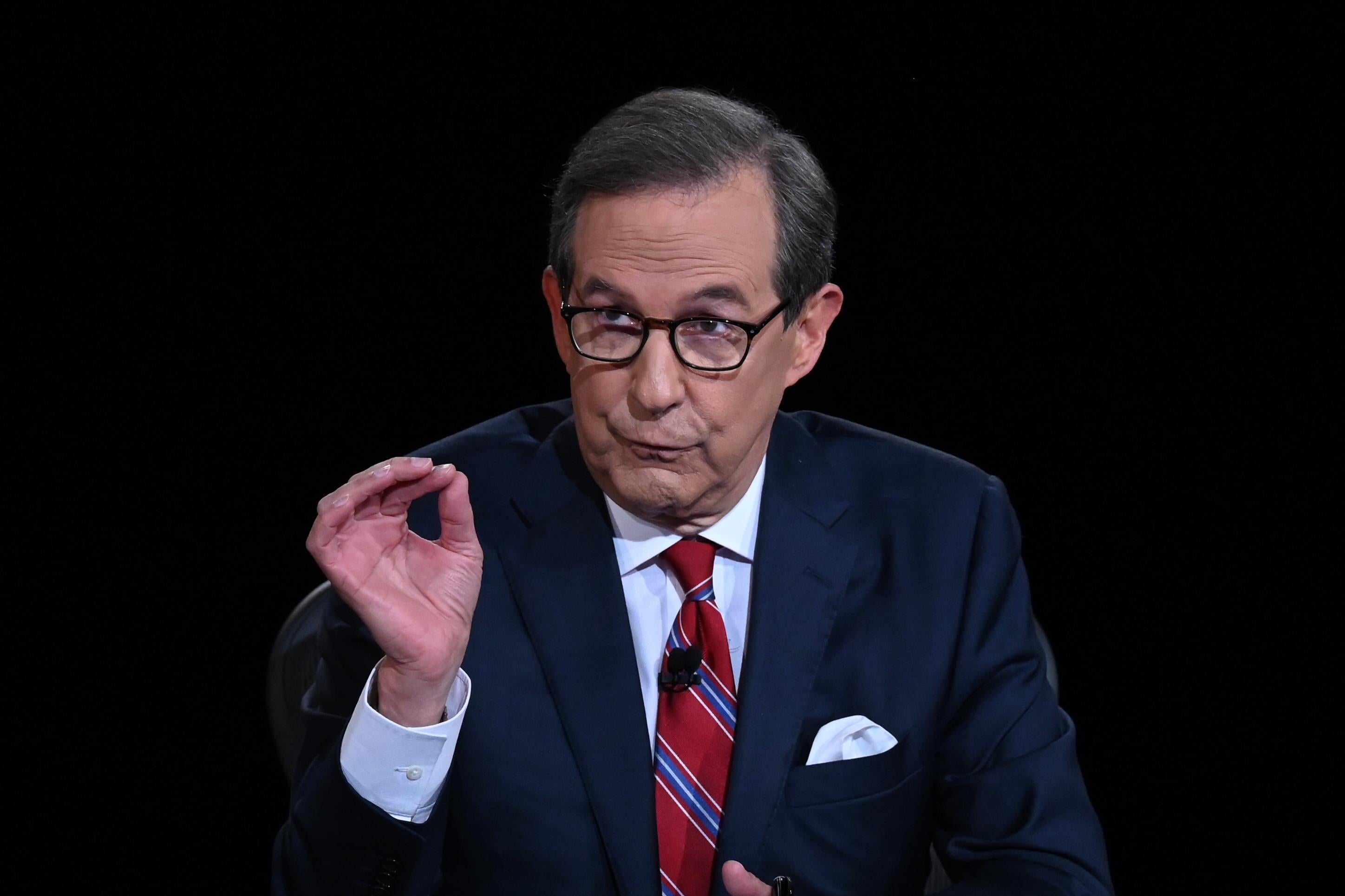 Chris Wallace seated and gesturing with one hand as he speaks