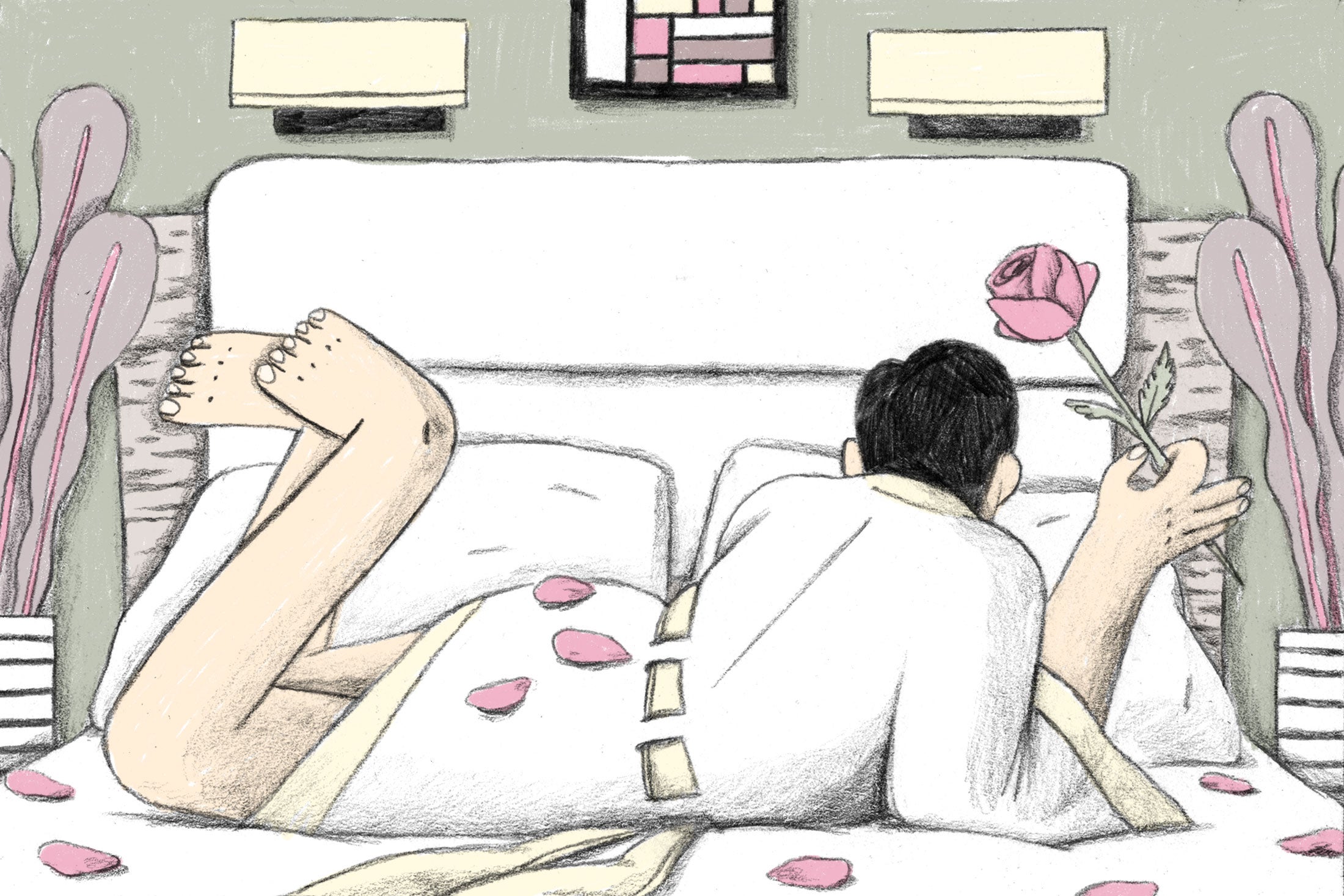 A man in a bathrobe lies on a bed covered in rose petals.