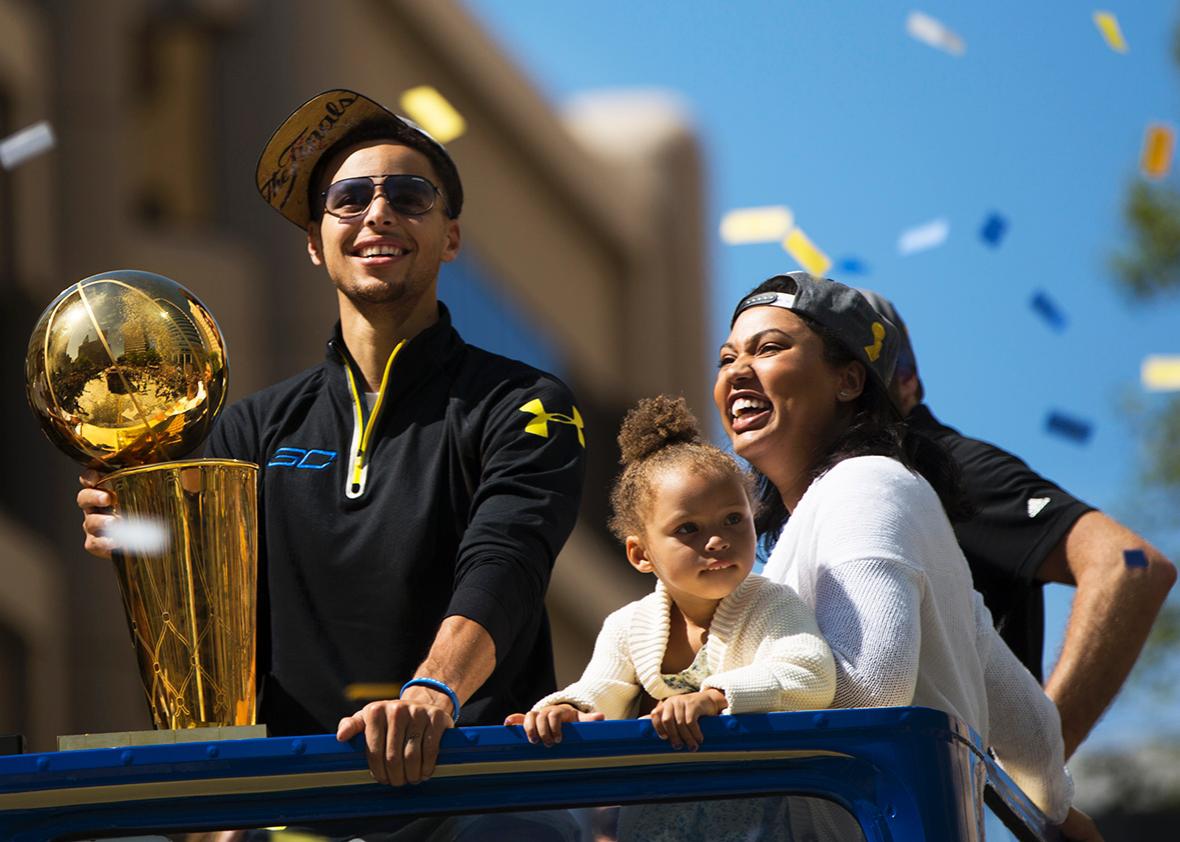Stephen Curry #30 of the Golden State Warriors, daughter Riley and wife Ayesha smile during the Golden State Warriors Victory Parade in Oakland, California. 