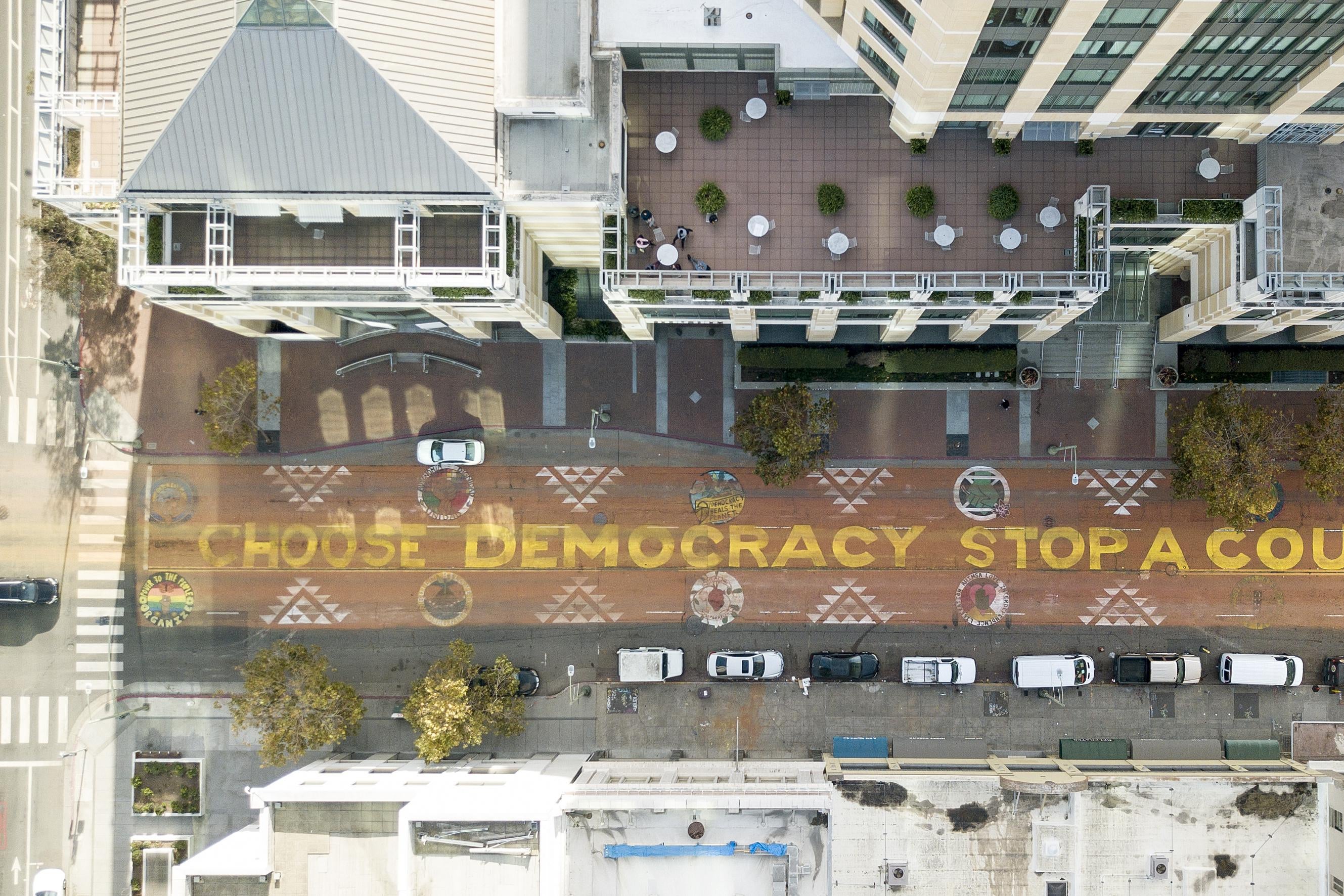 An aerial view of a mural on a street that reads “Choose Democracy Stop a Coup.”  