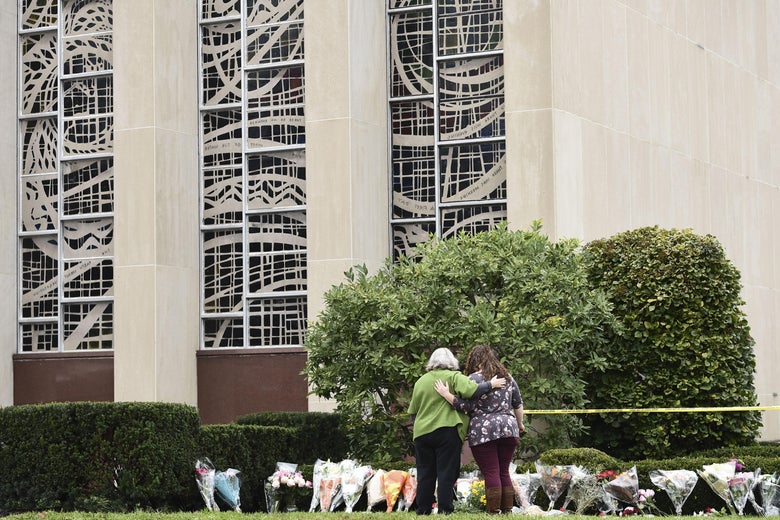 Women embrace in front of memorial flowers on October 28, 2018 outside of the Tree of Life Synagogue after a shooting there left 11 people dead in the Squirrel Hill neighborhood of Pittsburgh on October 27, 2018. 