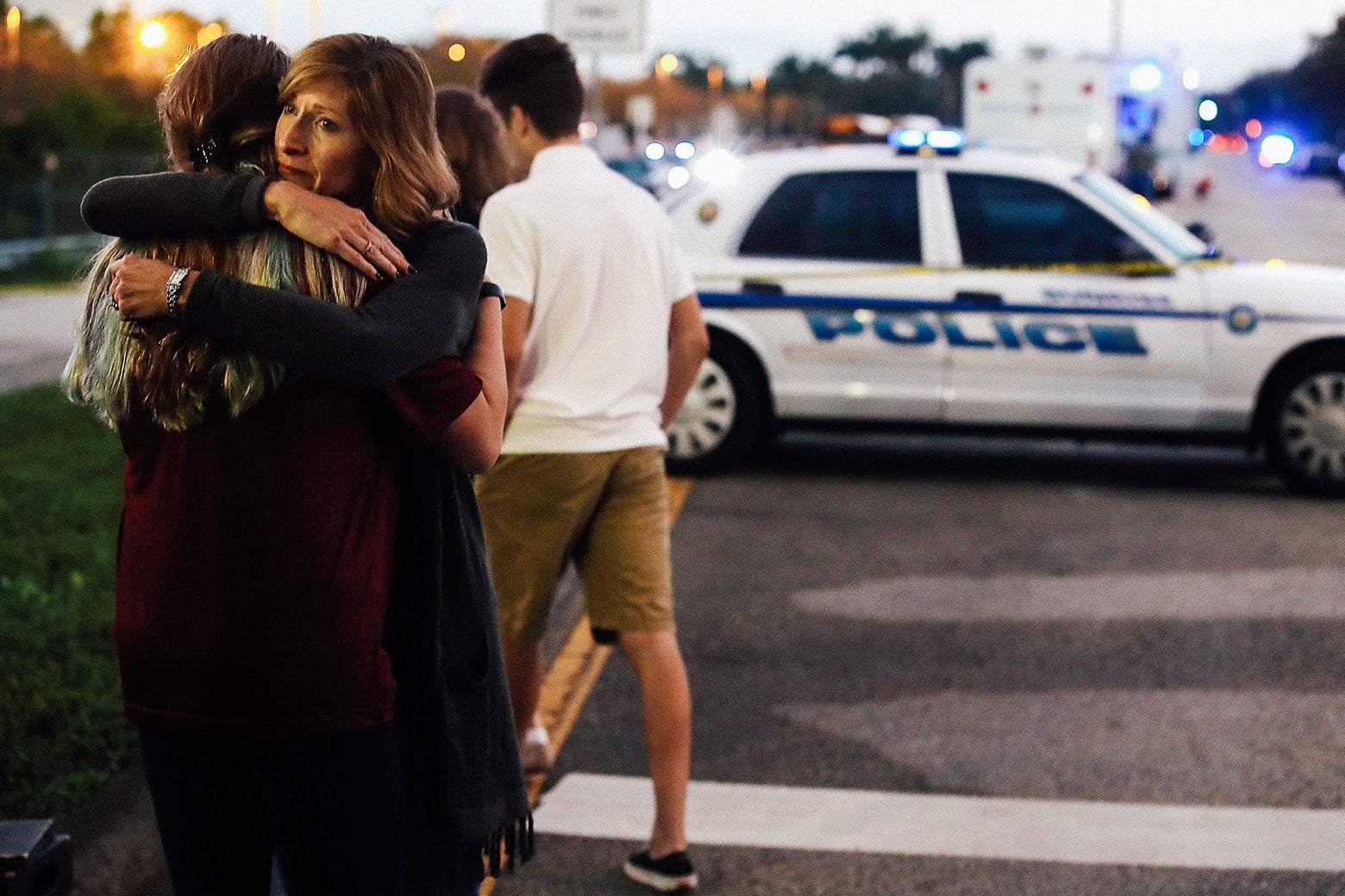 Kristi Gilroy hugs a young woman at a police checkpoint near Marjory Stoneman Douglas High School on Thursday in Parkland, Florida.