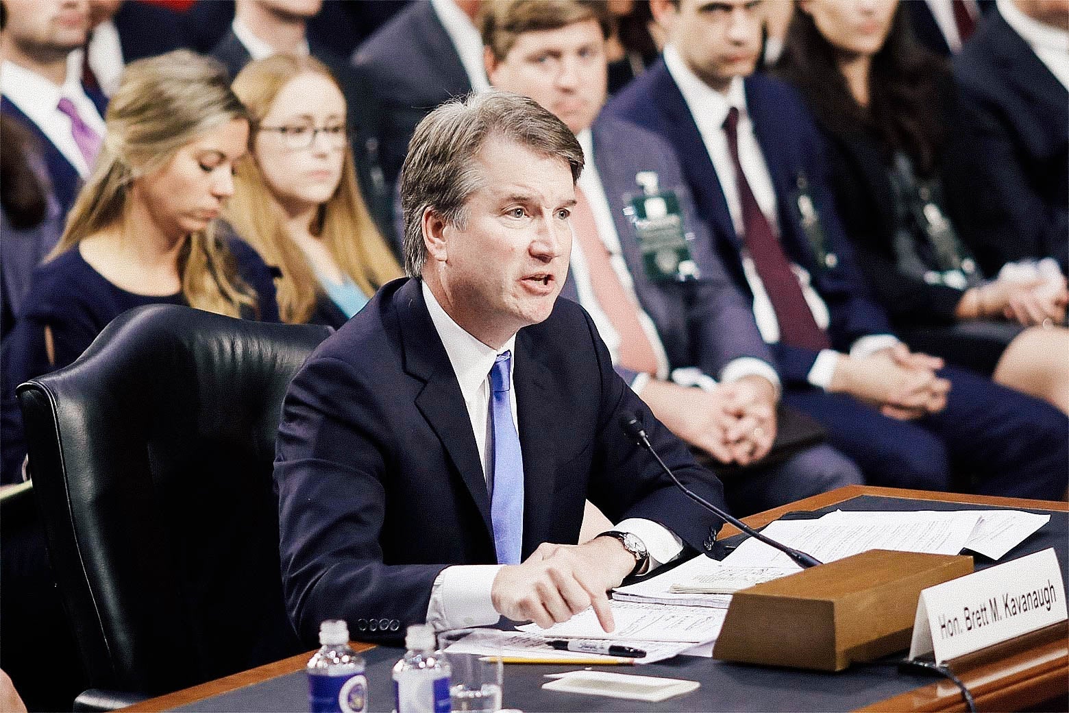 Kavanaugh points a finger toward the desk at which he's seated and speaking from in a confirmation hearing.