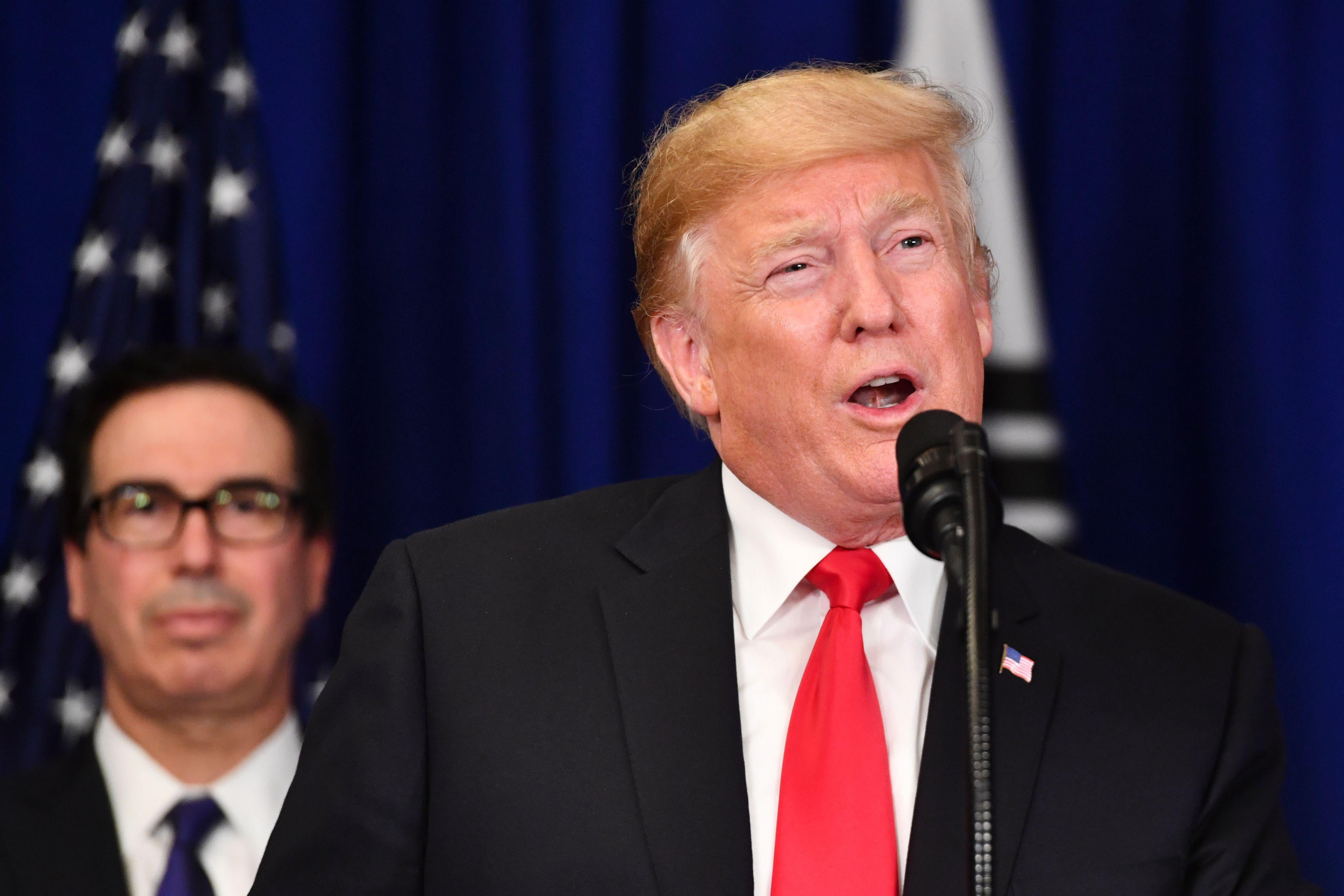 President Donald Trump speaks after a bilateral meeting as Treasury Secretary Steven Mnuchin looks on in New York on September 24, 2018.