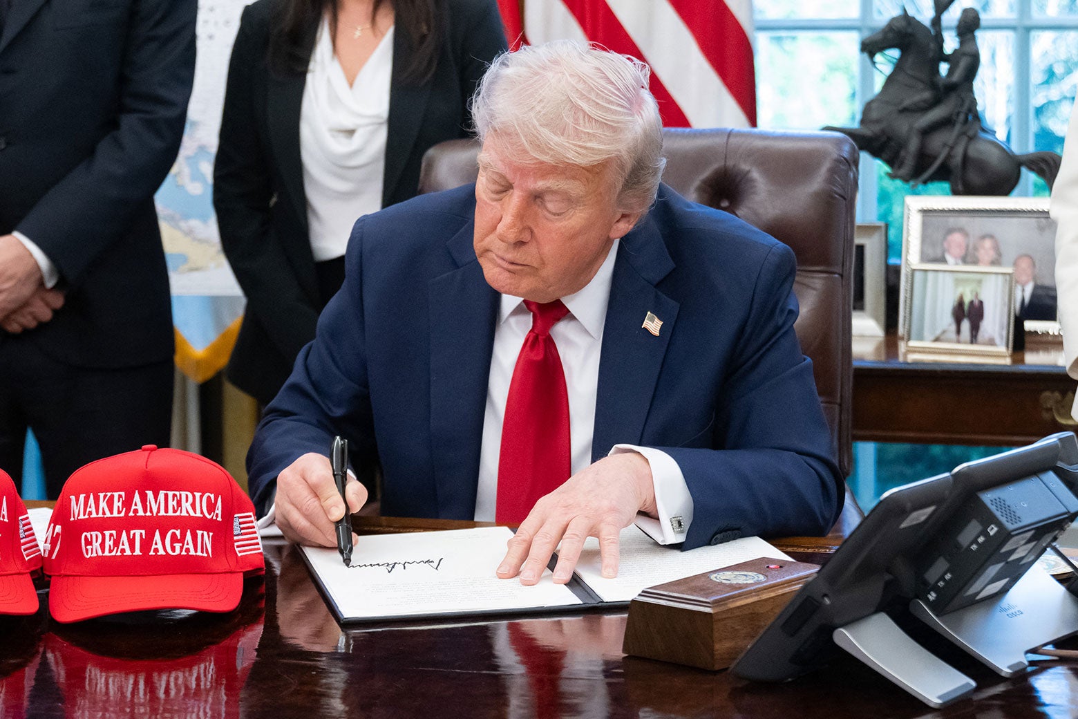 Trump's signature and a MAGA hat on the Resolute Desk.