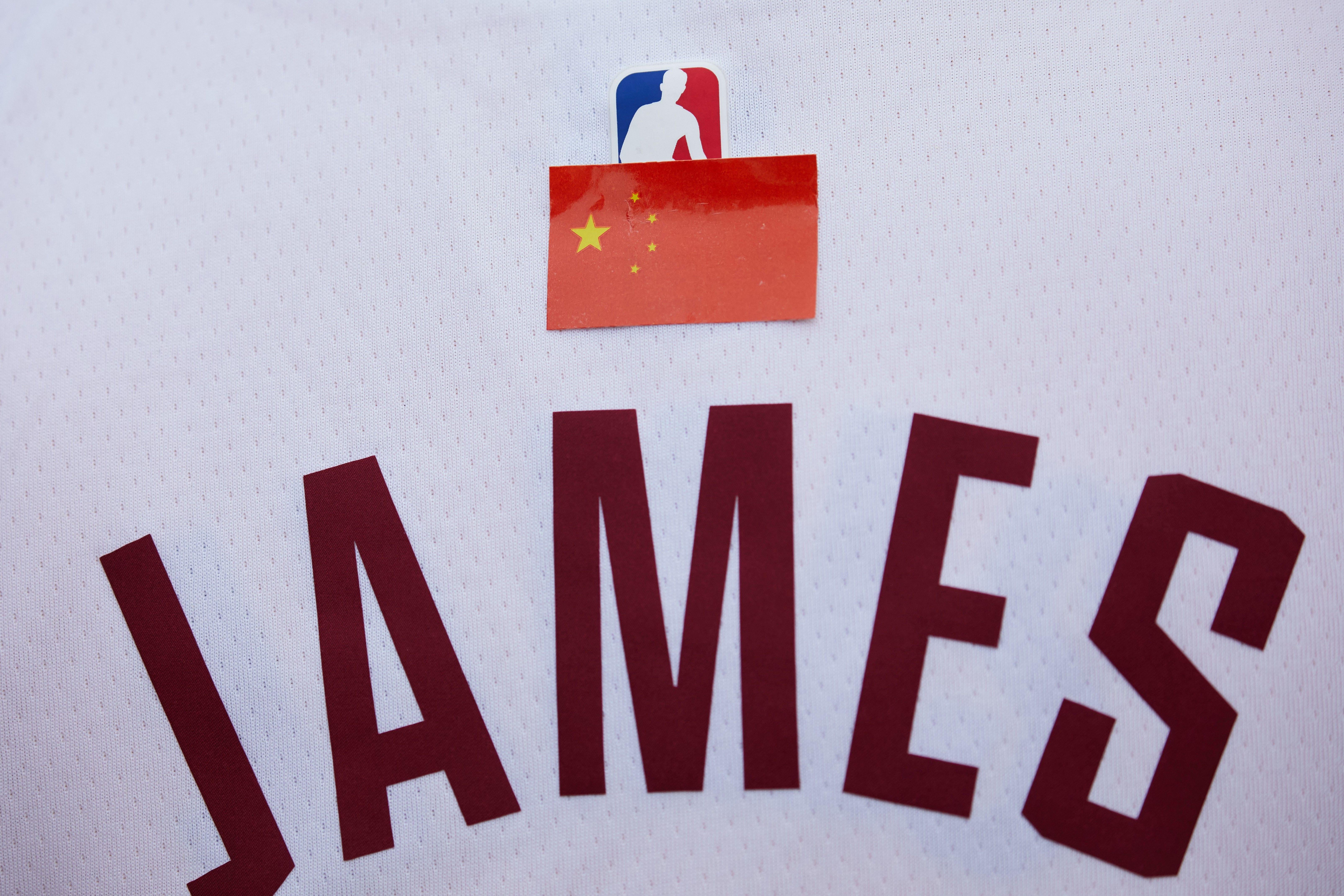 Close-up of the Chinese flag sticker over the NBA logo above the JAMES on a LeBron James jersey.