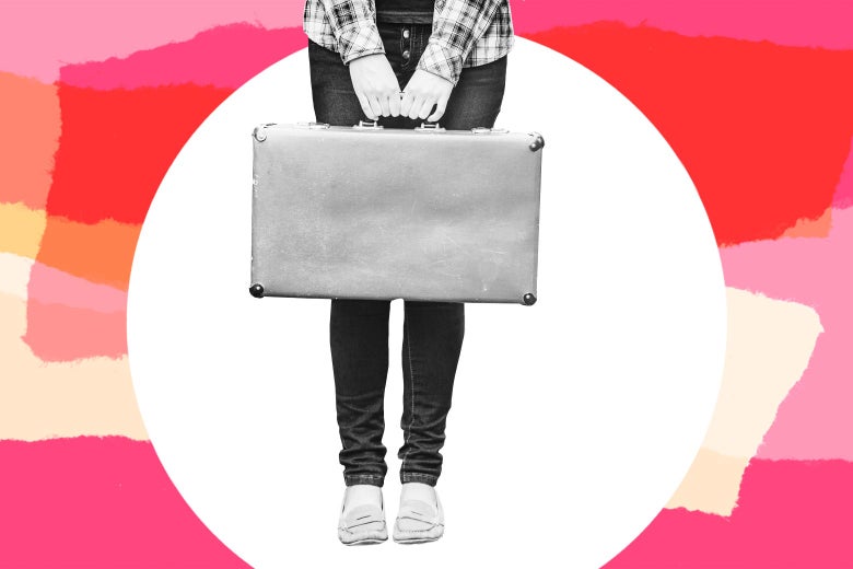 A woman holds a suitcase in front of her.
