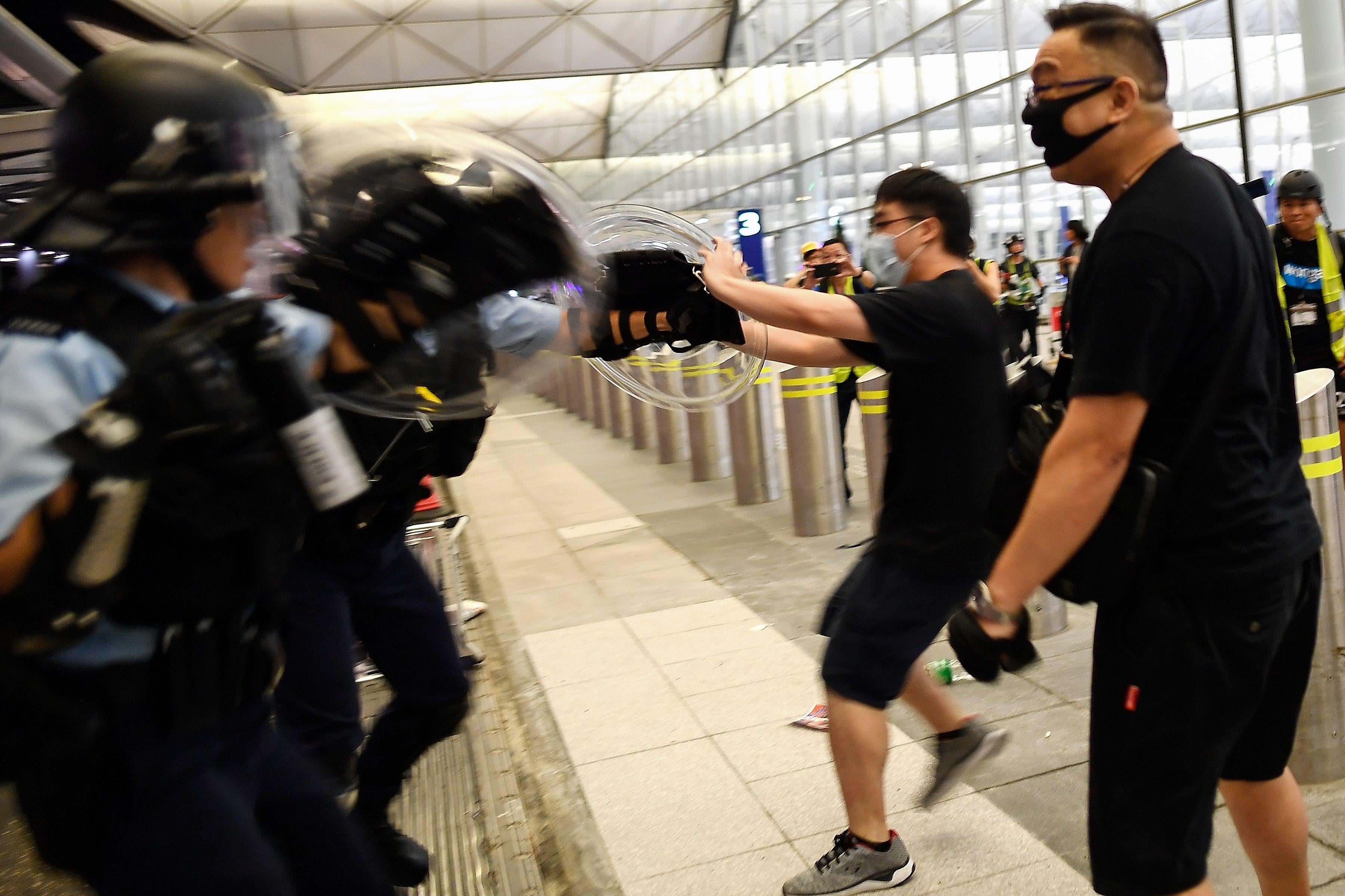 Police scuffle with pro-democracy protesters at the airport.
