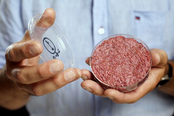 Professor Mark Post holds the world's first lab-grown beef burger during a launch event in west London August 5, 2013.