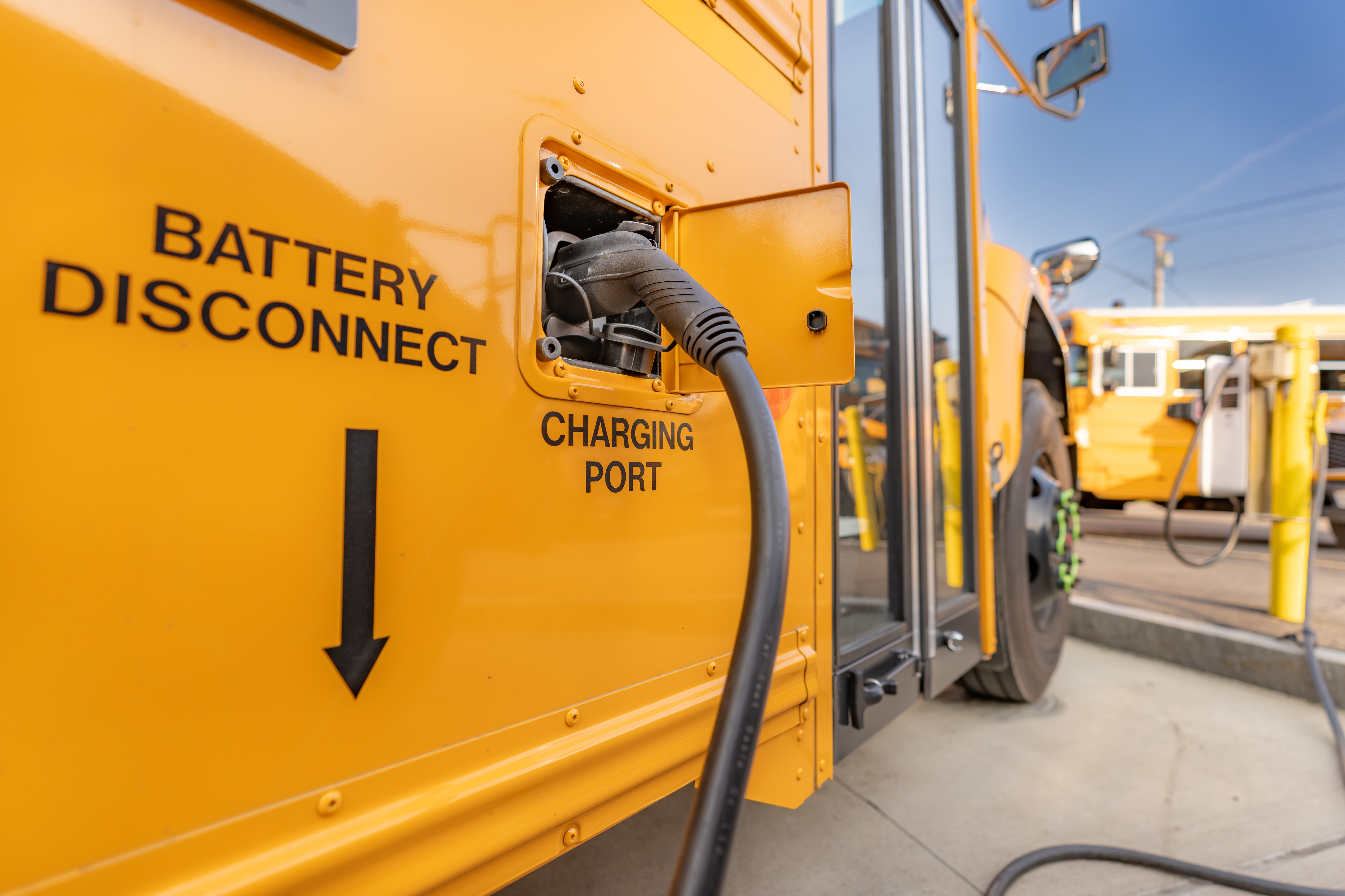 A close-up of the charging port on an electric yellow school bus. 