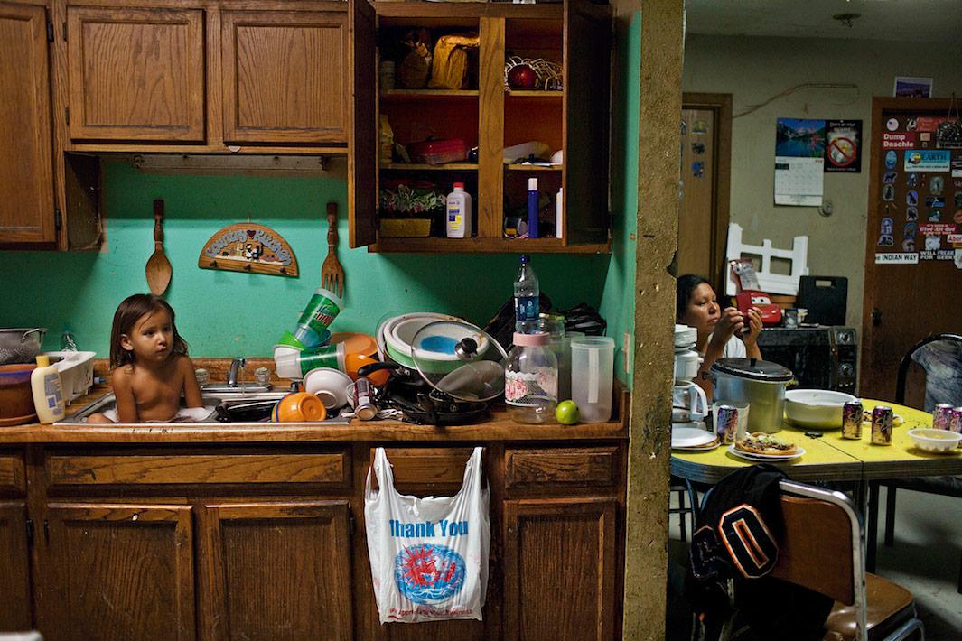 C. J. Shot, 3, bathes among dishes. 