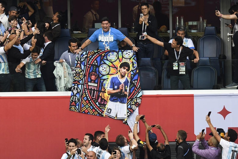 Retired Argentina forward Diego Maradona carries a poster bearing his portrait ahead of the Russia 2018 World Cup Group D football match between Nigeria and Argentina at the Saint Petersburg Stadium in Saint Petersburg on June 26, 2018. (Photo by Paul ELLIS / AFP) / RESTRICTED TO EDITORIAL USE - NO MOBILE PUSH ALERTS/DOWNLOADS        (Photo credit should read PAUL ELLIS/AFP/Getty Images)