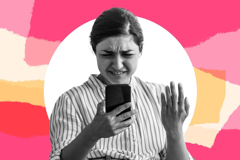 A woman holds her phone and looks annoyed as she reads a text.