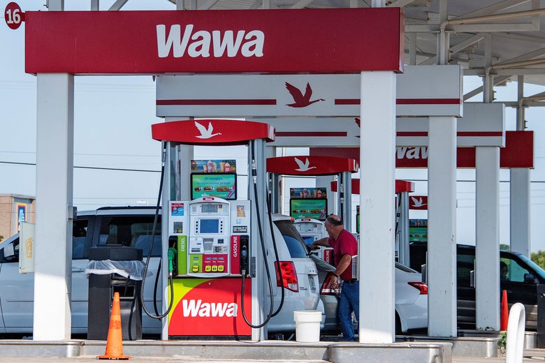 A man fills up his car with gas at a Wawa gas station.