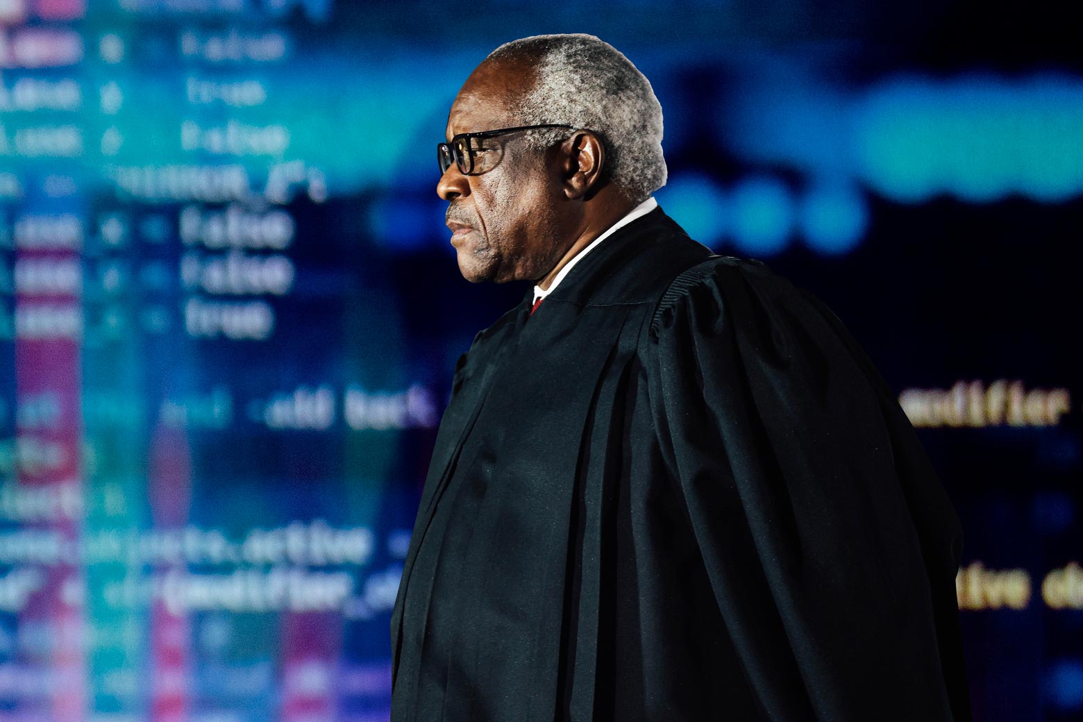 Clarence Thomas is seen against the background of a computer screen.
