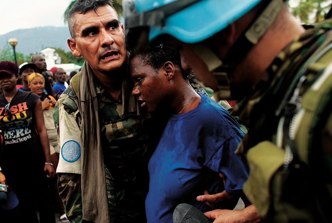 United Nations peacekeepers from Uruguay tend to pregnant Haitian woman who lost consciousness in a massive crowd during a rice distribution for earthquake-displaced Haitians on Jan. 25, 2010, in Port-au-Prince, Haiti.