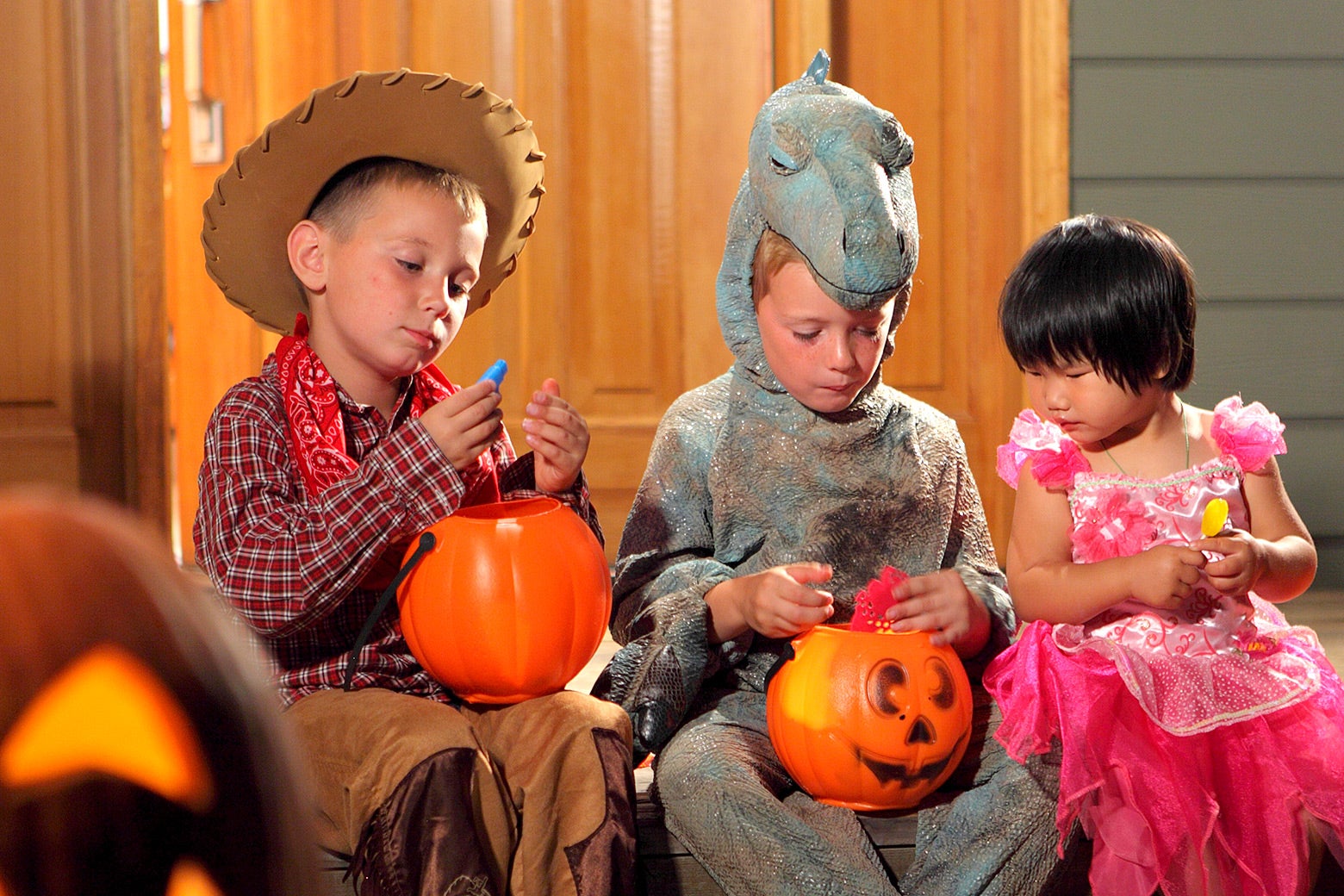 Three children going through Halloween candy.