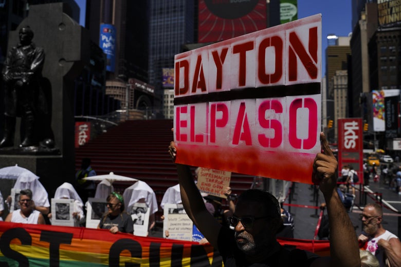 People hold signs and banners protesting gun violence.