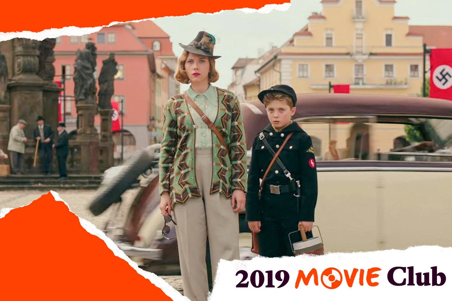 Scarlett Johansson stands next to the Jojo actor in a town square in a still from Jojo Rabbit. Text in the corner says, "2019 Movie Club."