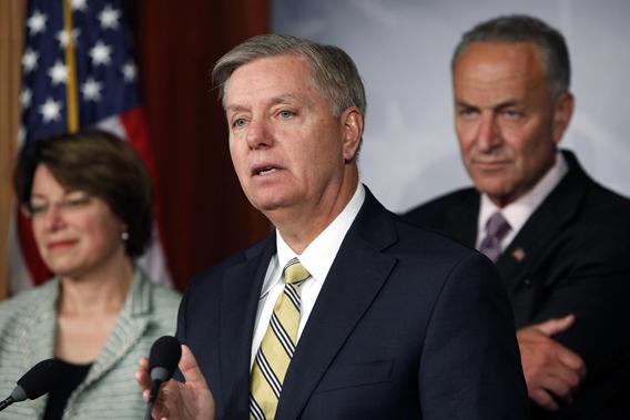 U.S. Senator Lindsey Graham (R-SC) and Senator Chuck Schumer (D-NY) (R) speak during a push for new bipartisan media shield legislation during a news conference at the U.S. Capitol in Washington.