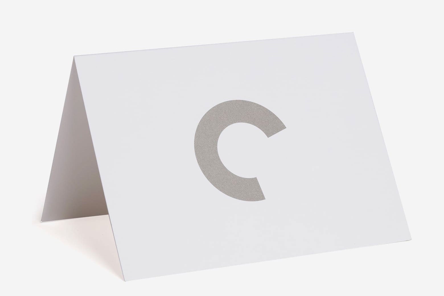 An open white card with a C cutout.