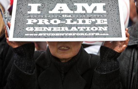 A woman shields herself from the rain at the March for Life rally in January 2012 in Washington, DC.