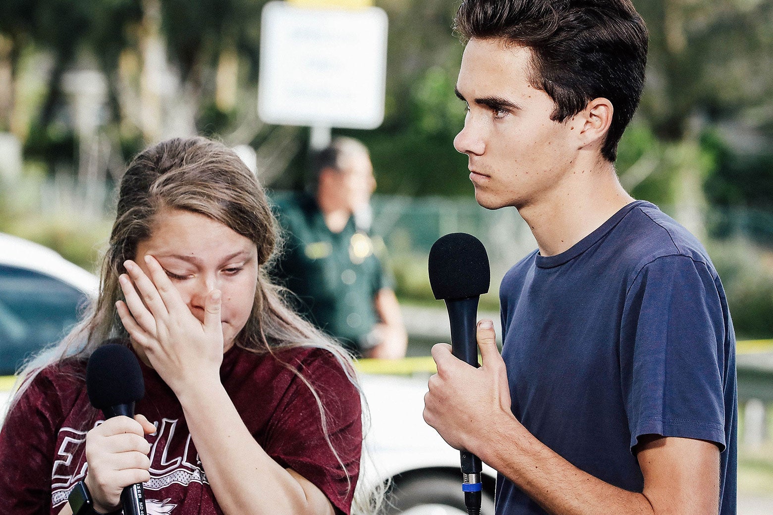 Kelsey Friend and David Hogg, holding microphones.