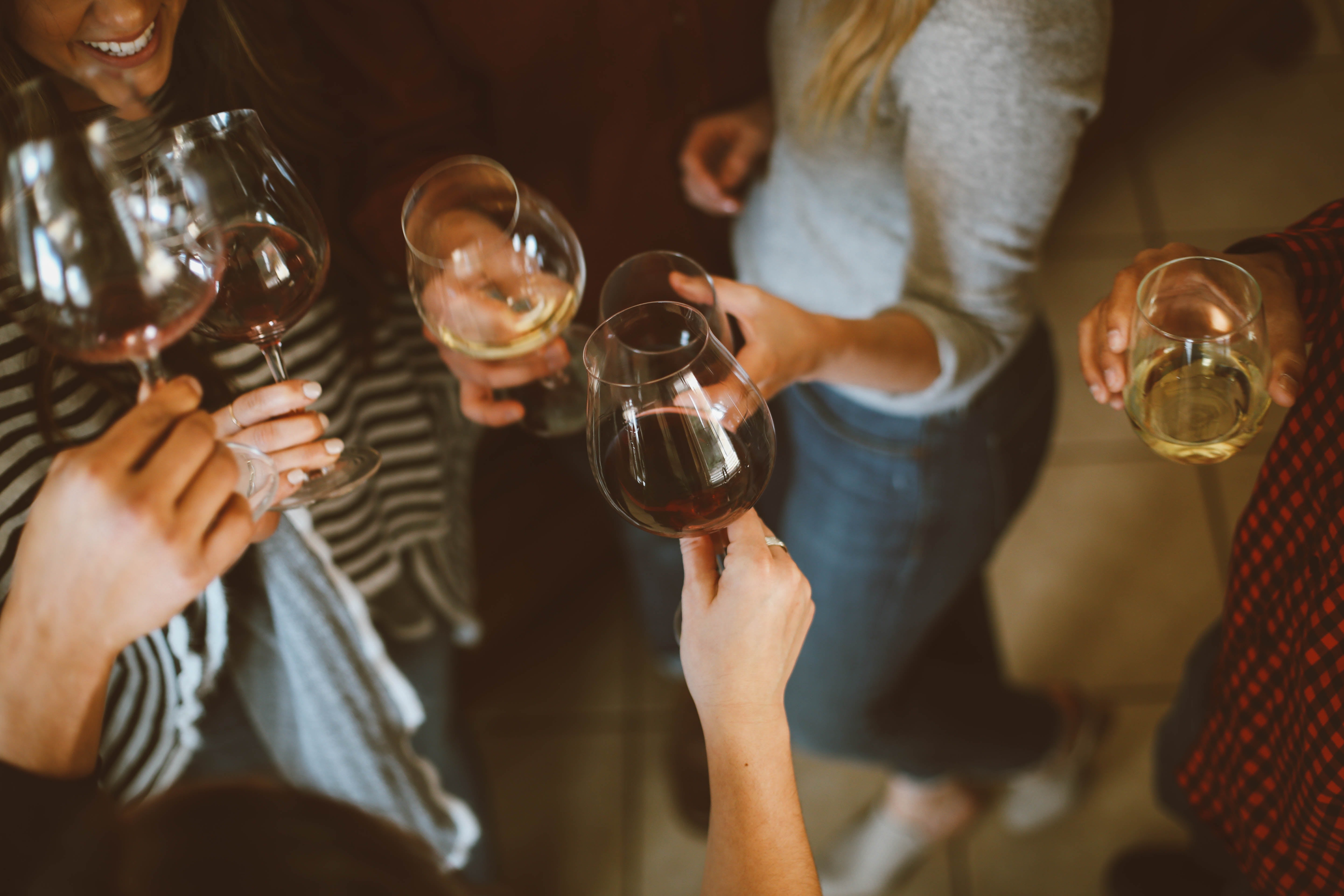 People standing in a circle toasting with glasses of wine