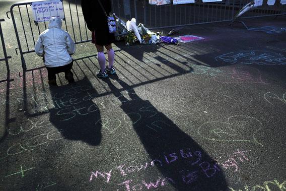 Two women stand  at a street memorial near the scene of twin bombings at the Boston Marathon on April 17, 2013 in Boston, Mass. 