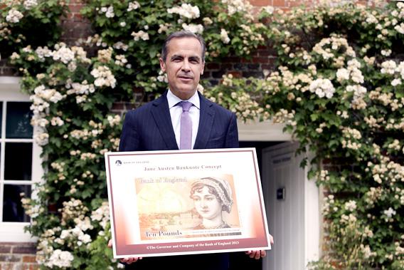 The Governor of the Bank of England, Mark Carney, poses for a photograph with the concept design for the new Bank of England ten pound banknote, featuring author Jane Austen, outside the Jane Austen House Museum in Chawton, southern England July 24, 2013.