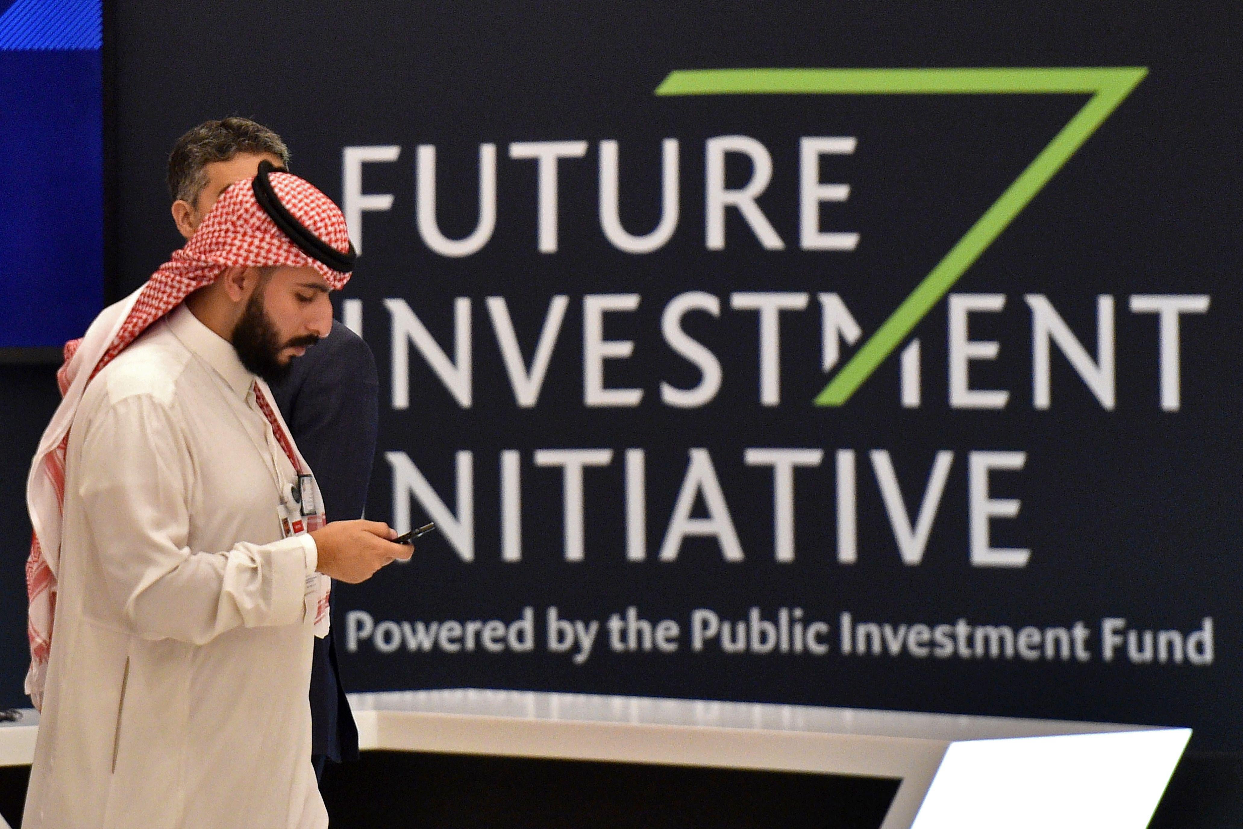 A man in front of the sign for the Future Investment Initiative in Riyadh.