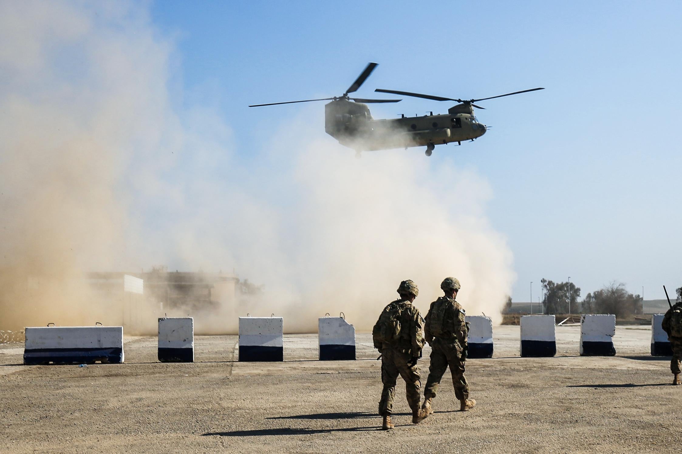A helicopter takes off above some U.S. soldiers in Iraq.