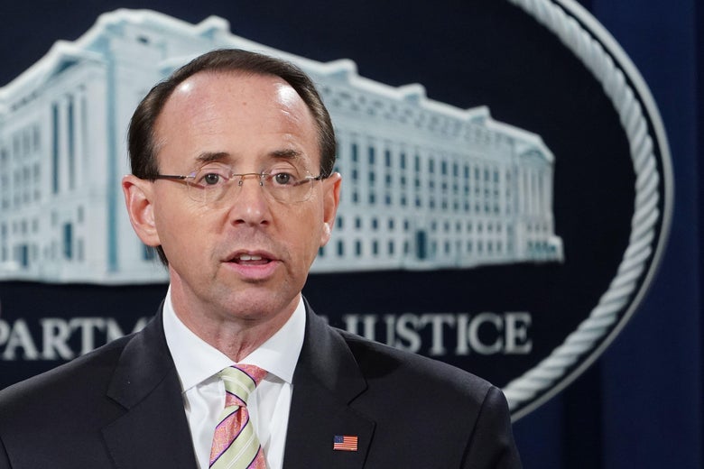 Rosenstein stands in front of a seal of the Department of Justice.