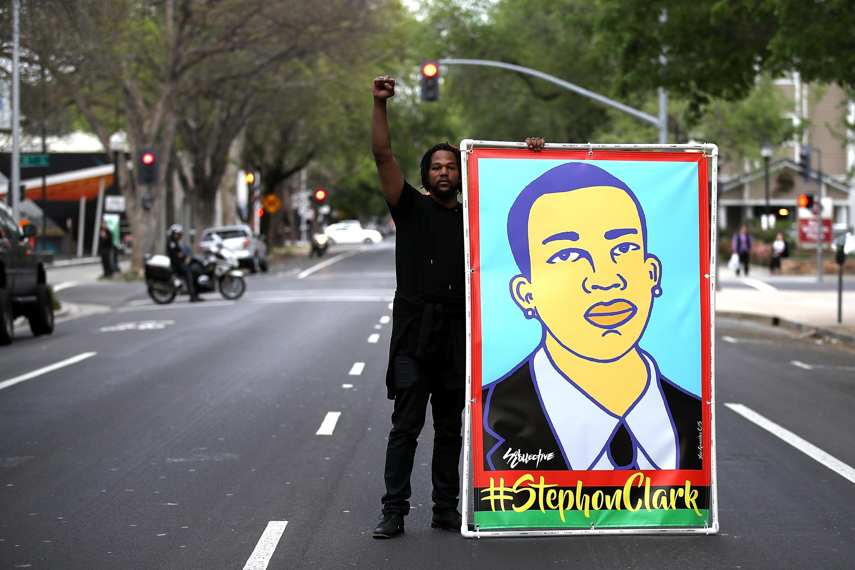 A Black Lives Matter protester holds an illustration of Stephon Clark during a march and demonstration through the streets of Sacramento on April 4, 2018 in Sacramento, California. 