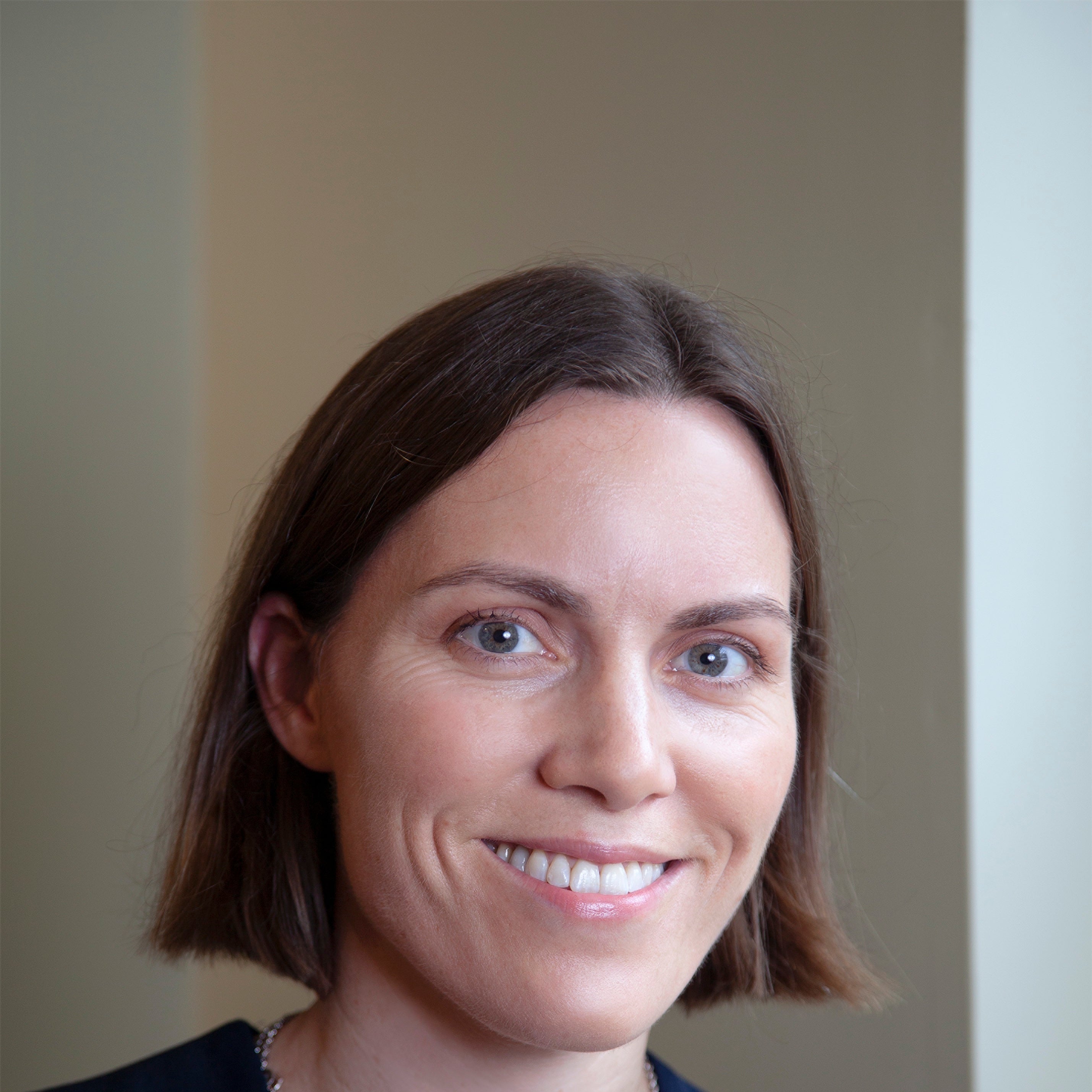 A woman with short brown hair smiles at the camera.