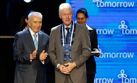 Israel's President Shimon Peres (L) stands with former U.S. President Bill Clinton after awarding him the Presidential Medal of Distinction at the fifth annual Presidential Conference in Jerusalem June 19, 2013. 
