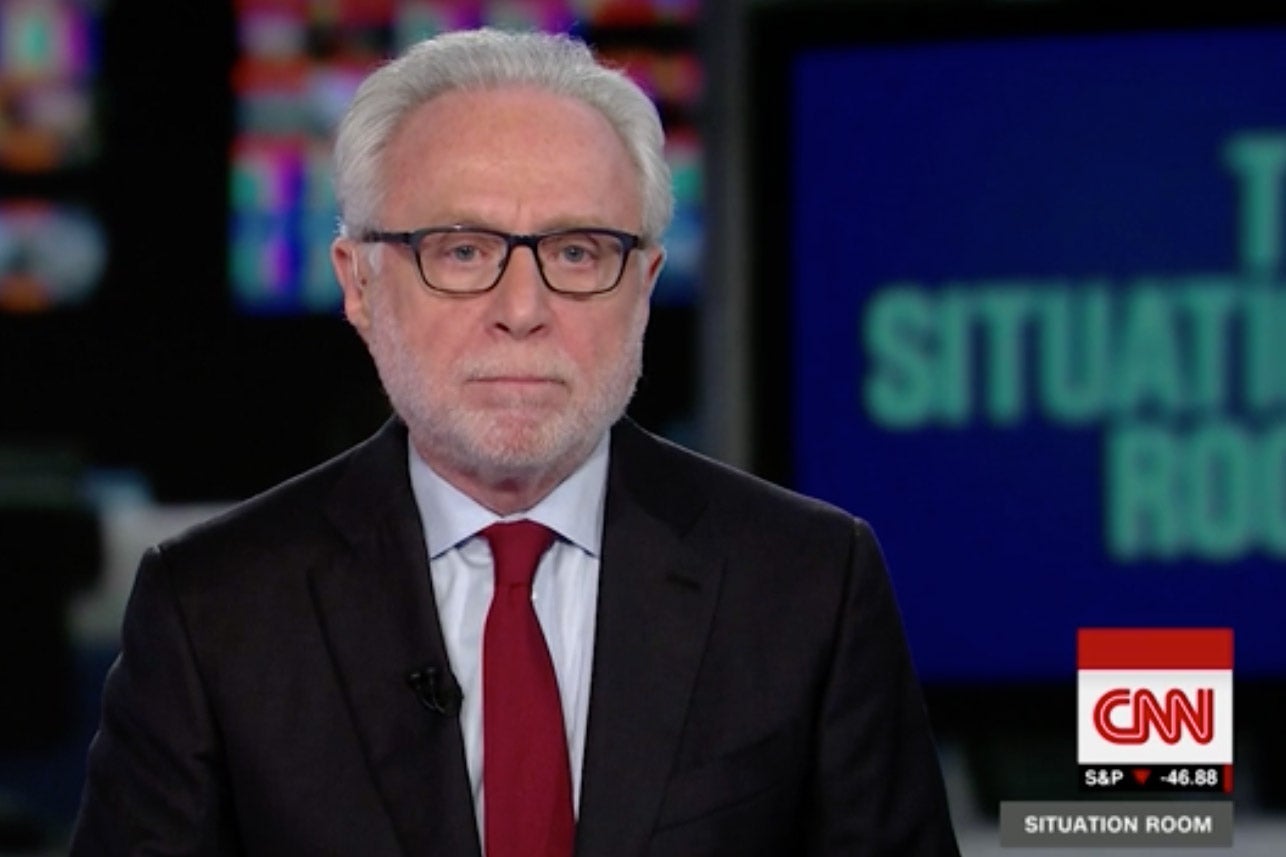 Wolf Blitzer stares at the camera with a blank expression during an episode of The Situation Room on CNN.