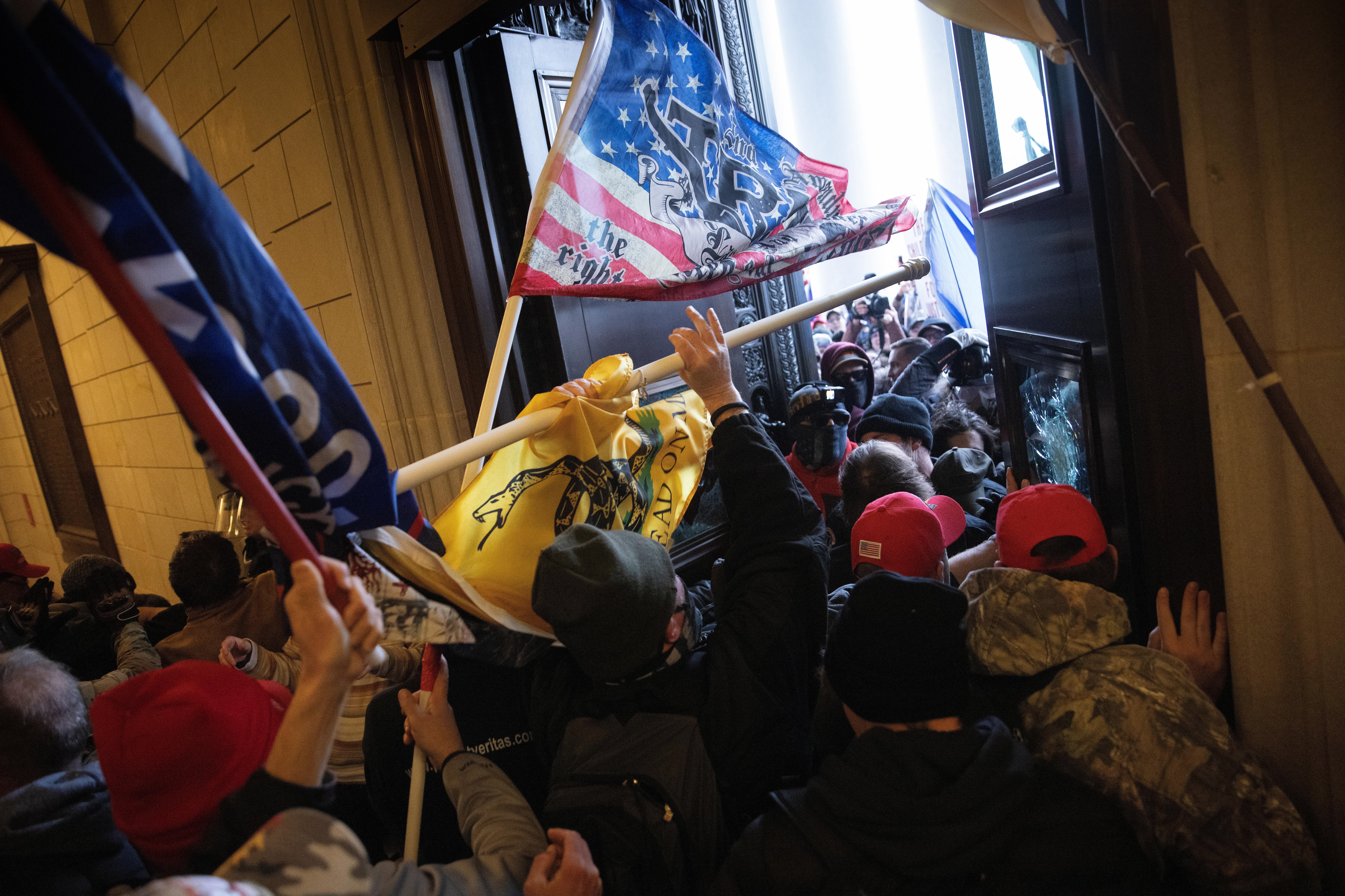 Rioters carrying Trump flags break through Capitol doors