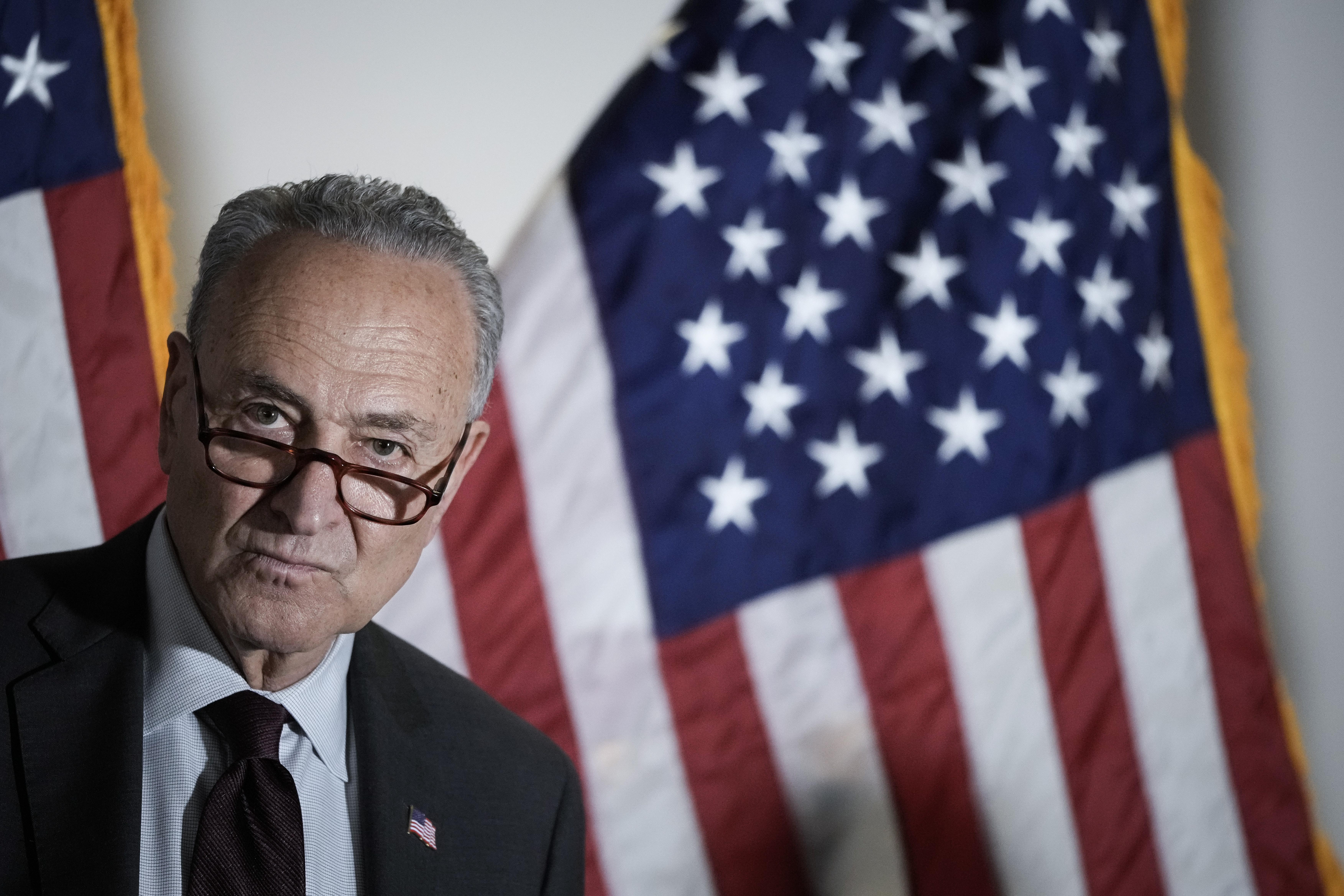 Chuck Schumer in front of an American flag.