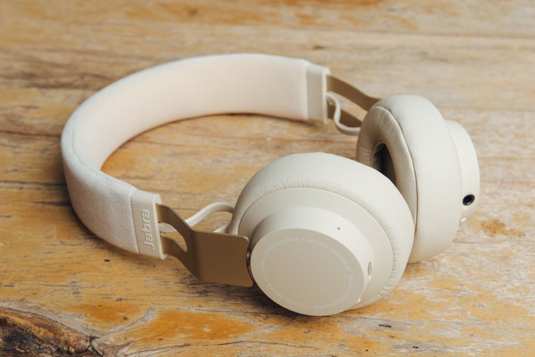 white Jabra headphones on wooden surface