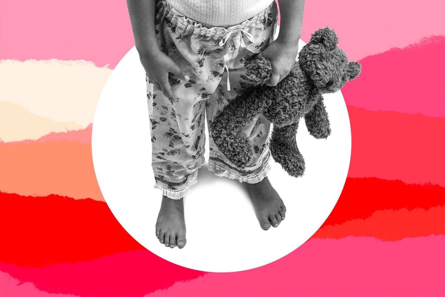 A young girl in her pajamas holding a stuffed animal.