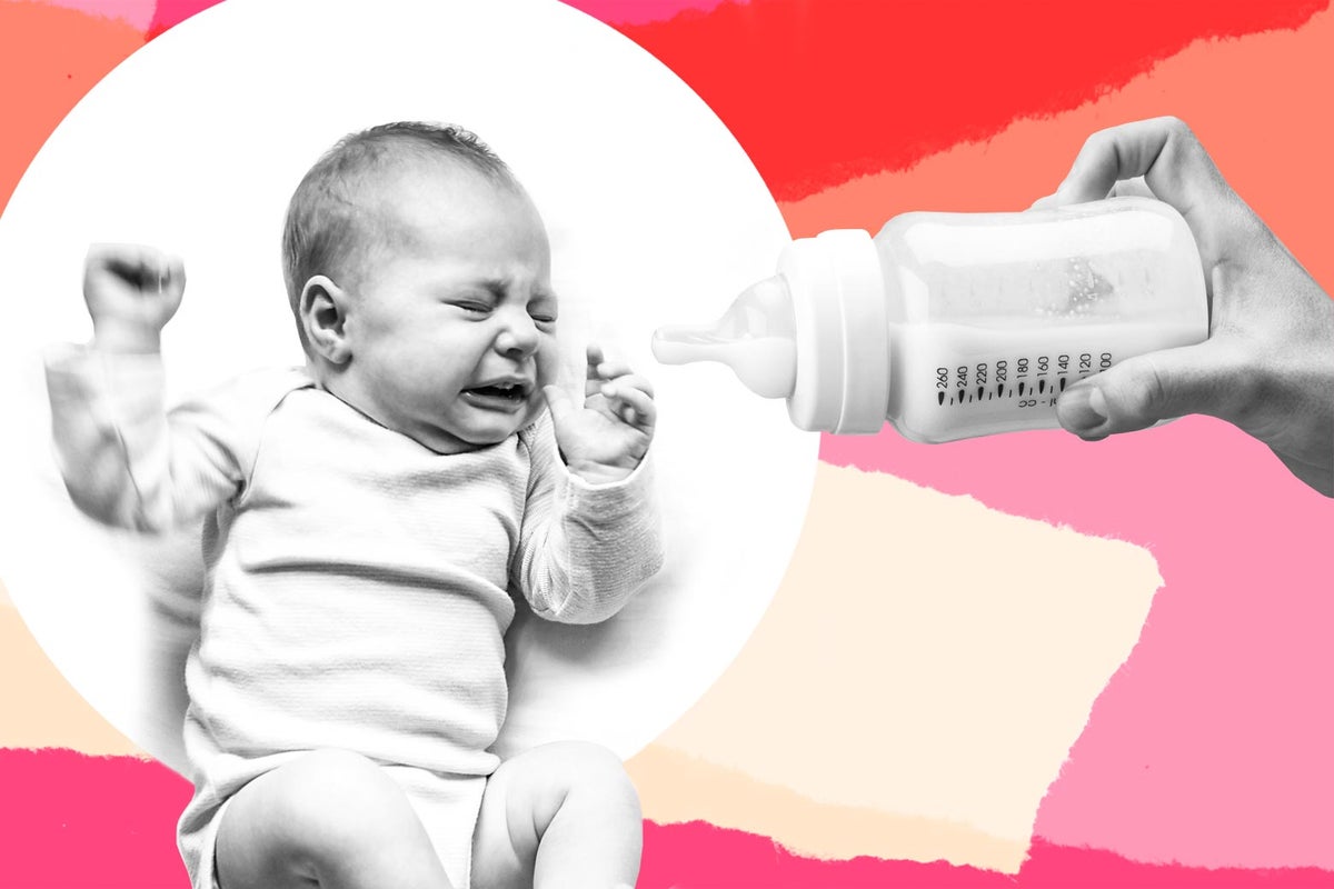 Toddler boy drinking milk from baby bottle stock photo - OFFSET